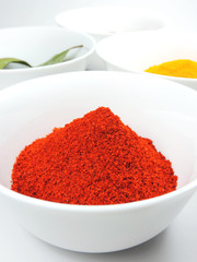 Spices on white. Curry or cumin, paprika powder, chili powder and laurel leafs