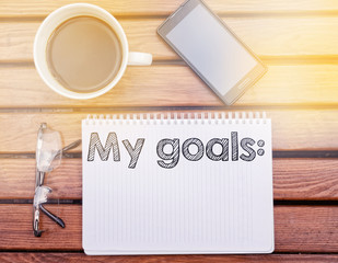 Notebook on table with text inside: My goals
