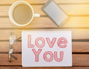 Notebook on table with text inside: Love You