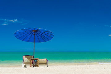  lounge chairs with sun umbrella on a beach