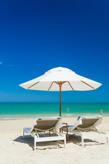  lounge chairs with sun umbrella on a beach