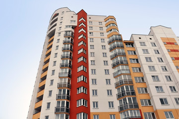 Fototapeta na wymiar Facade of a modern multistory residential building of red, white, yellow.