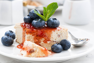 piece of cheesecake with berry jam on plate, closeup