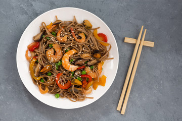 spicy buckwheat noodles with seafood and vegetables, top view