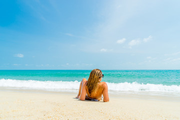 Fototapeta na wymiar Woman suntanning on the beach on the tropical beach