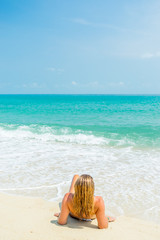 Fototapeta na wymiar Woman suntanning on the beach on the tropical beach