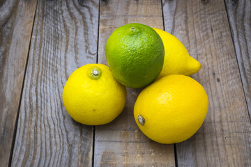 several mature citrus on an old wooden table - lemon and lime

