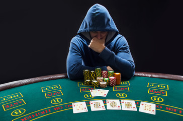 Portrait of a professional poker player sitting at pokers table 