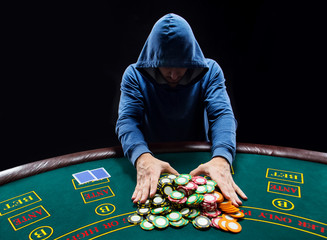 Poker player going all-in pushing his chips forward
