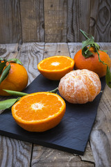 several mature citrus on an old wooden table on a blackboard - mandarins
