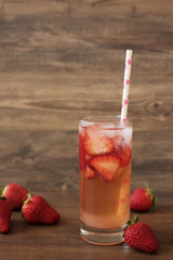 Homemade refreshing strawberry lemonade, fresh strawberries, wood background