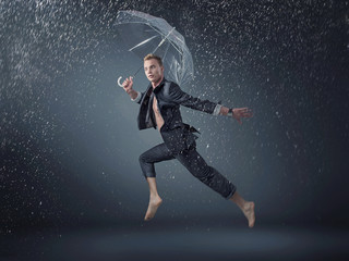 Fototapeta na wymiar Handsome man jumping and dancing in the rain