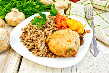 Cutlets of turkey with buckwheat in plate on board