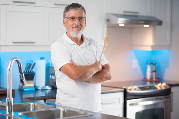 Senior man standing in his renovated, modern kitchen,