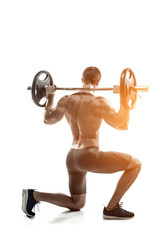 Plakat Fitness man standing on knee and holding barbell, rear view