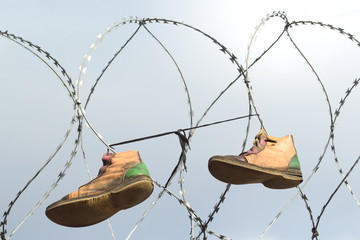 Old shoes hanging on the razor wire