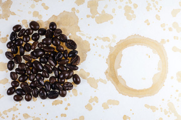 Coffee beans and coffee stains on a white tablecloth..
