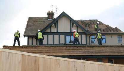 Team of construction workers taking off the roof from building © Savo Ilic