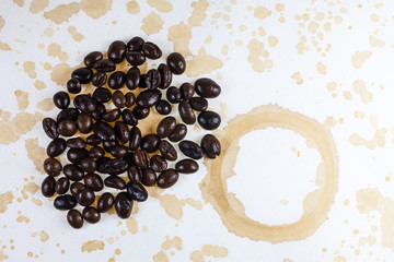 Coffee beans and coffee stains on a white tablecloth..