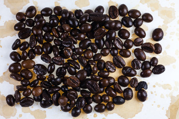 Coffee beans and coffee stains on a white tablecloth..