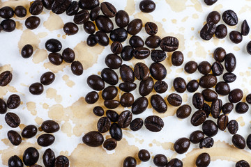 Coffee beans and coffee stains on a white tablecloth..