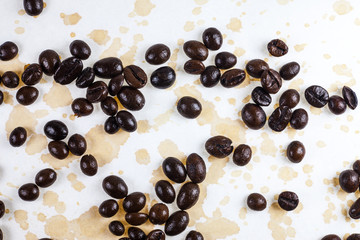 Coffee beans and coffee stains on a white tablecloth..