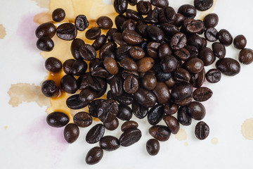 Coffee beans and coffee stains on a white tablecloth..