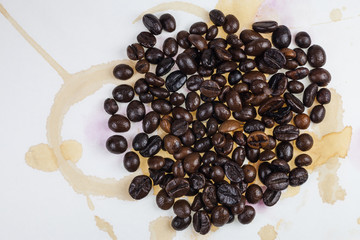 Coffee beans and coffee stains on a white tablecloth..
