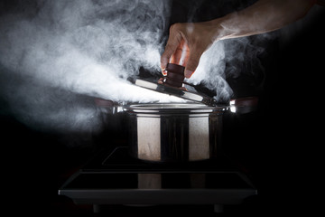 hand of chef open hot stream pot with beautiful studio lighting