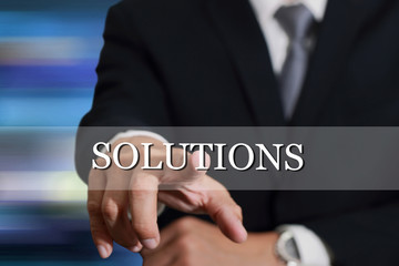Businessman hand touching Solutions sign on virtual screen as Success concept.