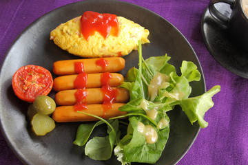 Set of breakfast, omelet, sausage and fresh vegetable salad.
