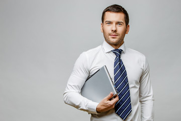 Handsome stylish businessman on grey background