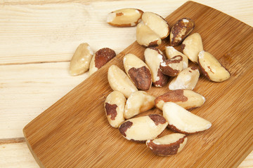 Brazil nut on a white background (Bertholletia excelsa), blanched close up isolated on the table on the wooden background