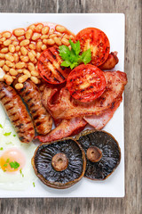 Full English breakfast with bacon, sausage, egg, beans and mushrooms
