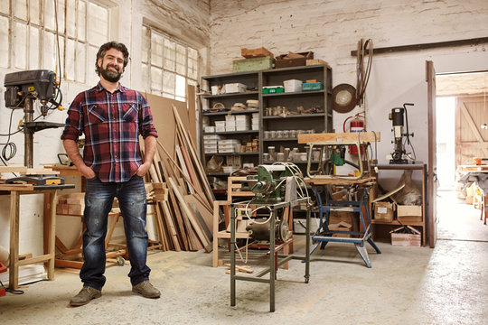 Craftsman in his workshop with heavy-duty woodwork machinery