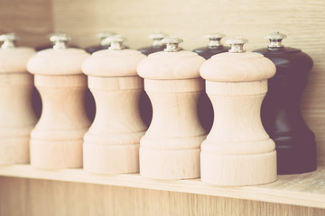 Vintage wooden salt and pepper grinders on a shelf