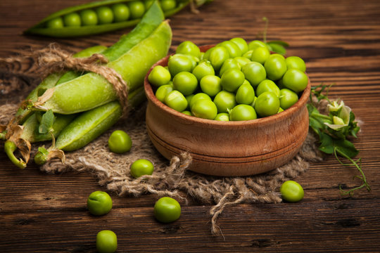Fresh organic green peas on a wooden background.Rustic style.