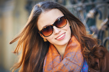 Outdoor portrait of beautiful redhead young woman in sunglasses