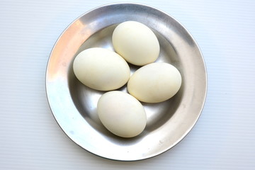 Salted duck eggs in dish on white background.