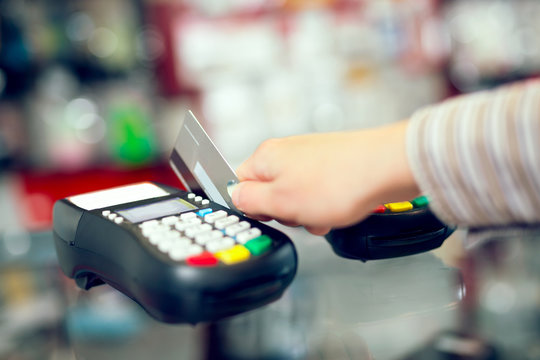 Female hand doing purchase through payment machine