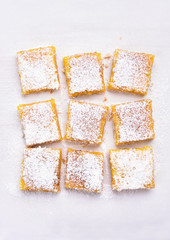 Dessert lemon bars over baking paper, top view