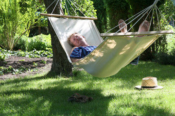 Man relaxing in a hammock in a summer garden