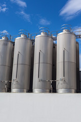 Giant industrial tanks on the bright blue sky