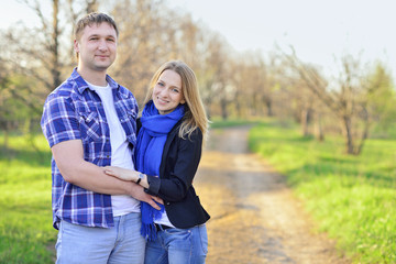 Obraz premium Young couple outdoors in spring, hugs, sunshine, smile