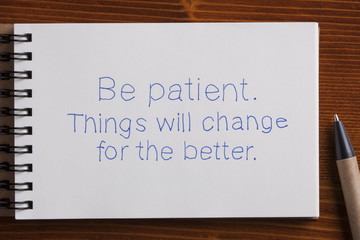 Obraz premium Be patient handwritten text on a notebook with pen