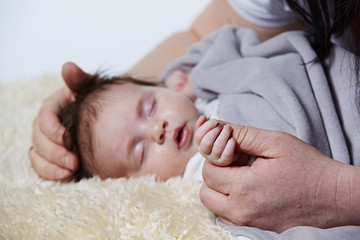 Obraz na płótnie Canvas Baby hält die Hand der Mutter und schläft 1