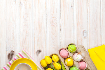 Easter background with colorful eggs and yellow tulips