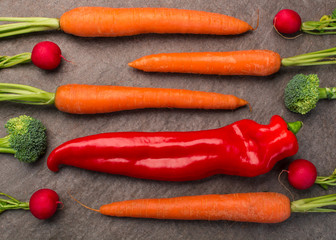 Rote Bio-Paprika mit Gemüse auf Granitplatte arrangiert, Draufsicht