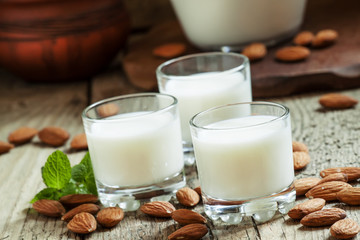 Almonds and milk, old wooden background, rustic style, selective