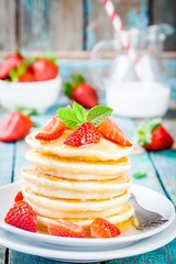 Homemade pancakes with honey and strawberries